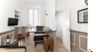 A hotel room with a bed, a desk with a globe, a TV, and a chair. - Côté Rome Colosseo (Rome)