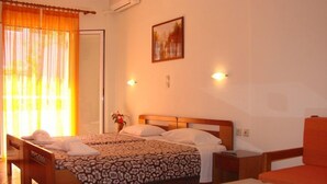 Habitación de hotel con cama, una silla, una mesa y un cuadro en la pared.