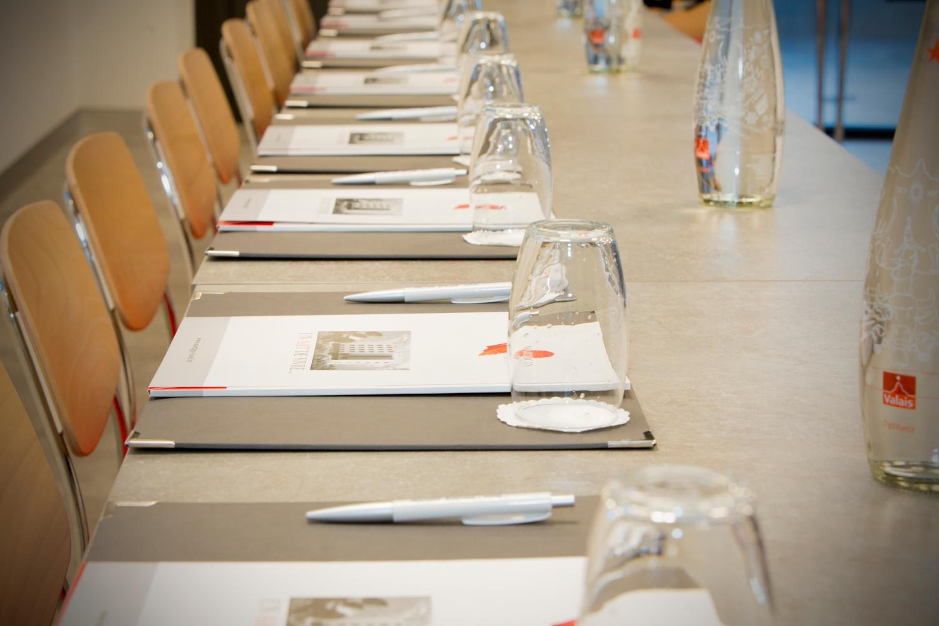 A conference room with a long table, chairs, and water bottles.