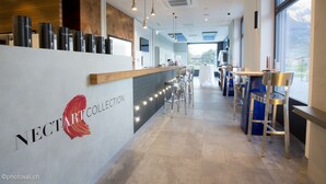 A modern reception area with a wooden counter, bar stools, and a large window offering a view.