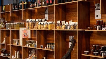 A wooden shelf display with various items including bottles, jars, and snacks.