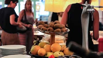 Montaje de bufé con diversos alimentos, platos y un tostador.