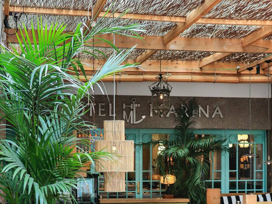 An outdoor seating area with wicker furniture and potted plants.