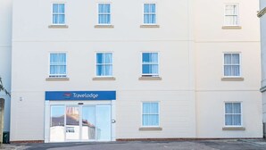 A Travelodge hotel with a flat facade, multiple windows, and a blue sign above the entrance. - Travelodge Ryde Isle of Wight (Ryde)