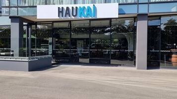 Un edificio moderno con fachada de vidrio y un letrero que dice 'HAUKAI'.