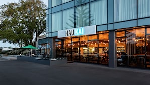 Un edificio moderno con un amplio muro de cristal y un cartel que dice "HAUKAI".