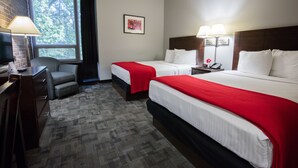 A hotel room with two beds, a desk, a chair, and a large window. - Rutgers University Inn and Conference Center (New Brunswick)