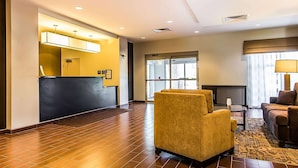 A hotel lobby with a reception desk, seating area, and large windows. - Wingate by Wyndham Jonesboro/Hodge (Jonesboro)