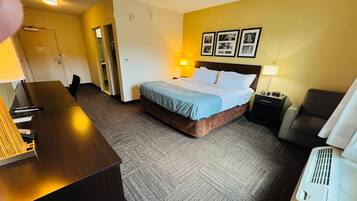 Ein Hotelzimmer mit Bett, Schreibtisch, Stuhl, Lampe und Heizung.