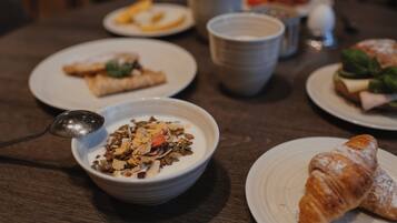 Una mesa con platos de comida, tazones y vasos.