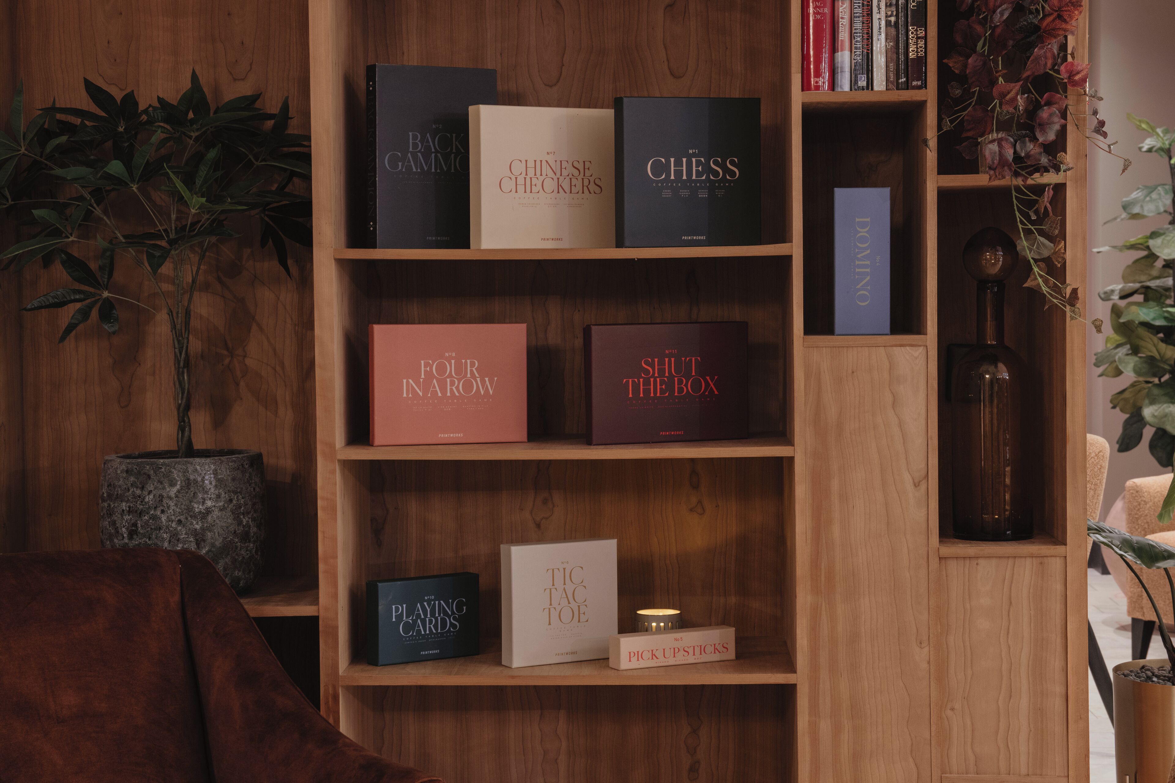 A wooden bookshelf with various board games and books.