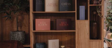 A wooden bookshelf with various board games and books.