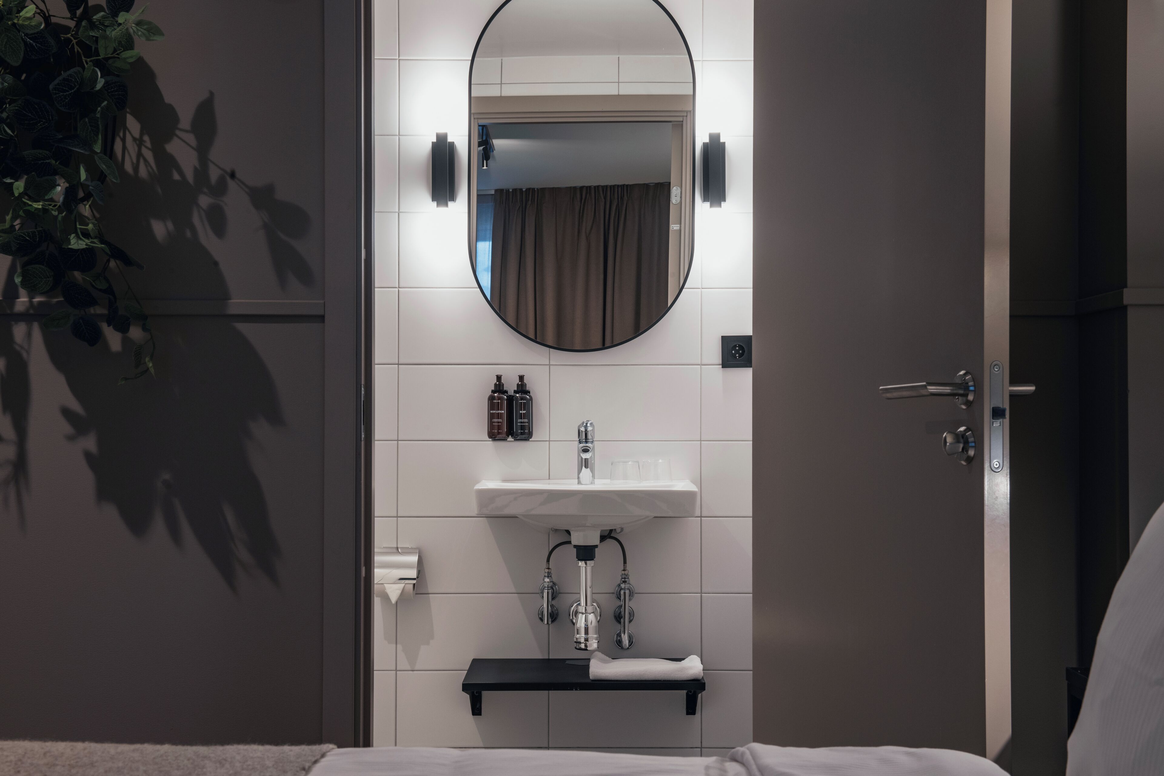 A bathroom with a white sink, a mirror, and a towel rack.