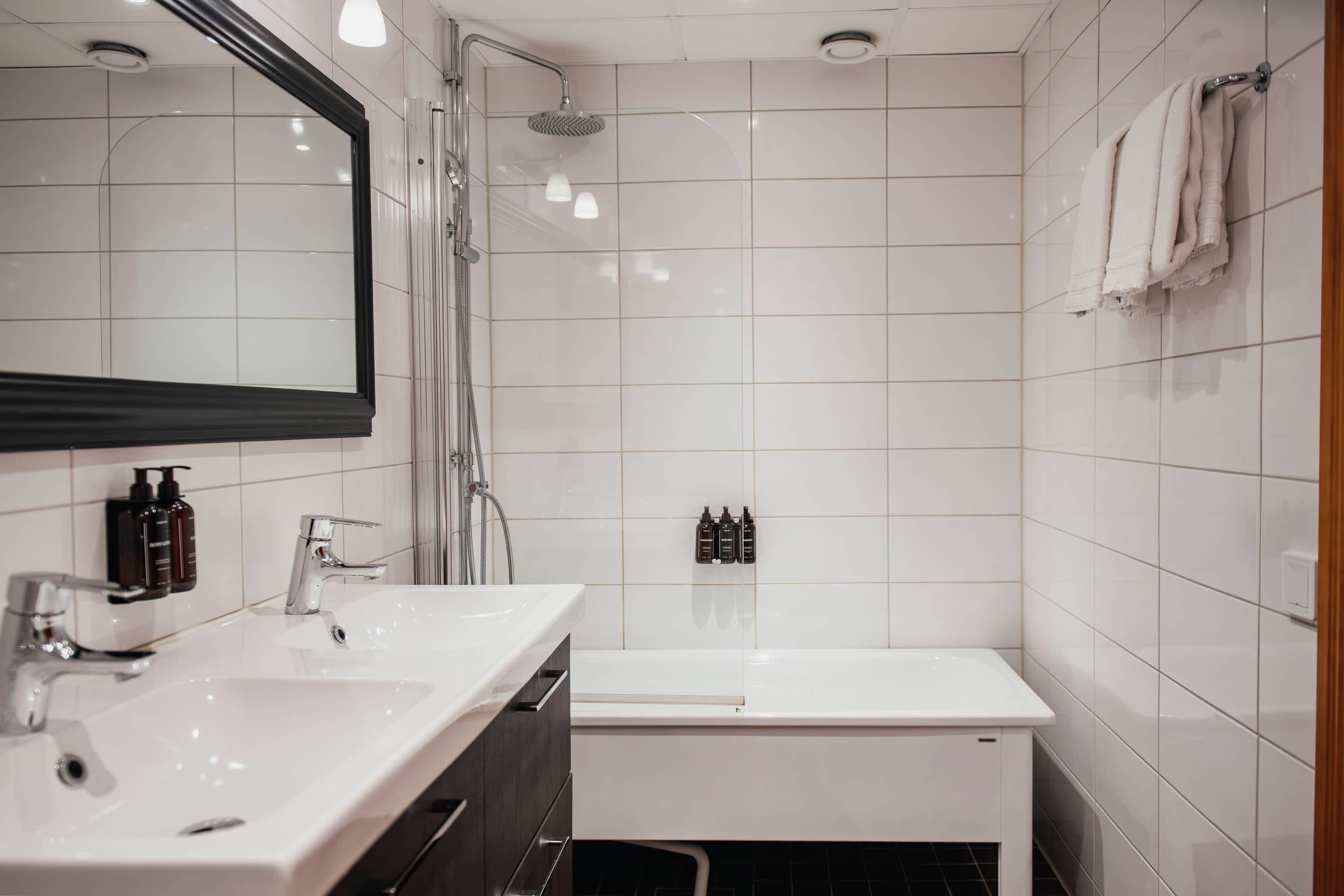 A modern bathroom with two sinks, a shower, and a bathtub.