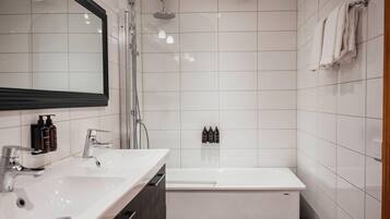 A modern bathroom with two sinks, a shower, and a bathtub.