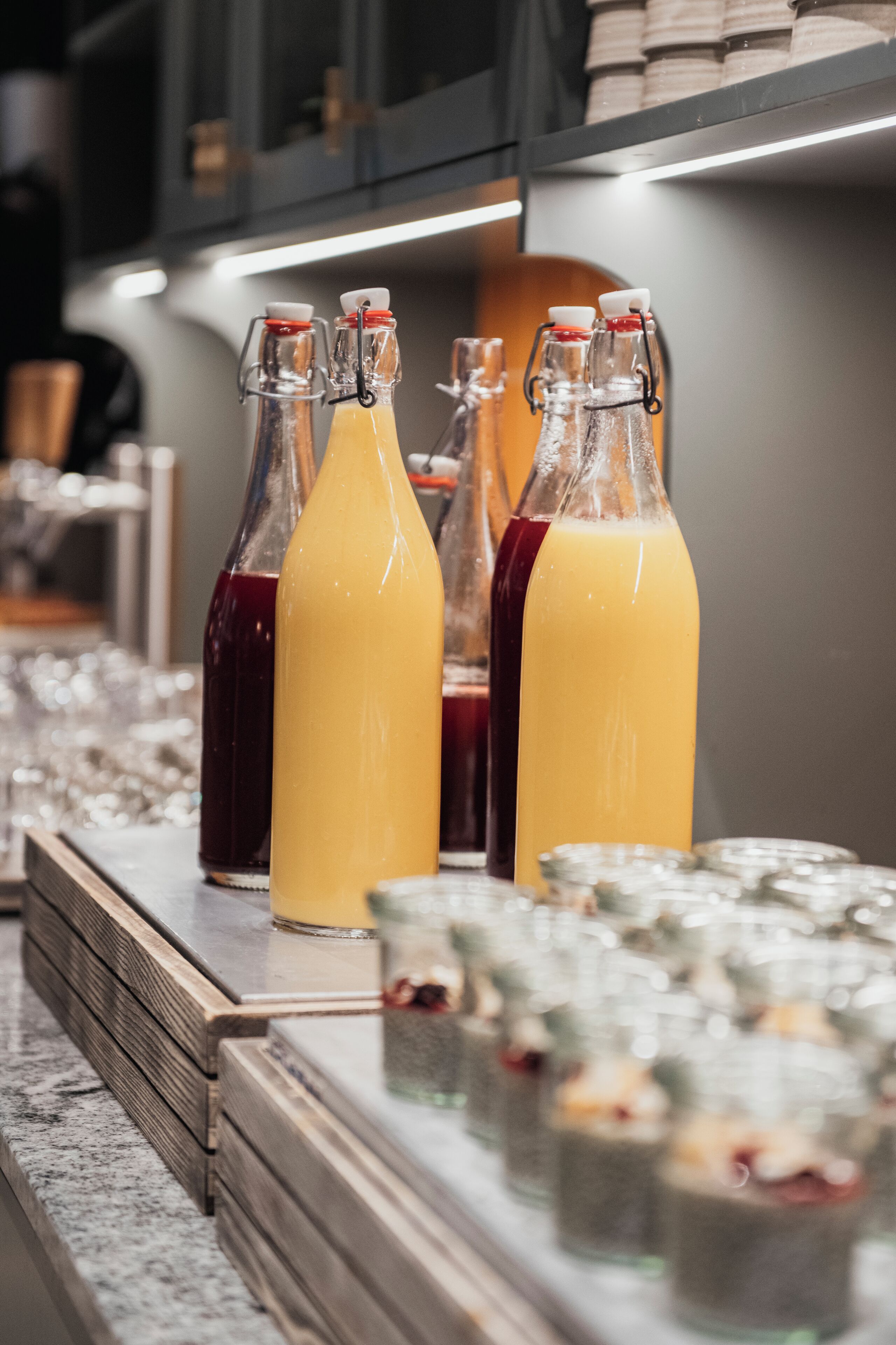 A bar area with bottles of drinks and glasses on the counter.
