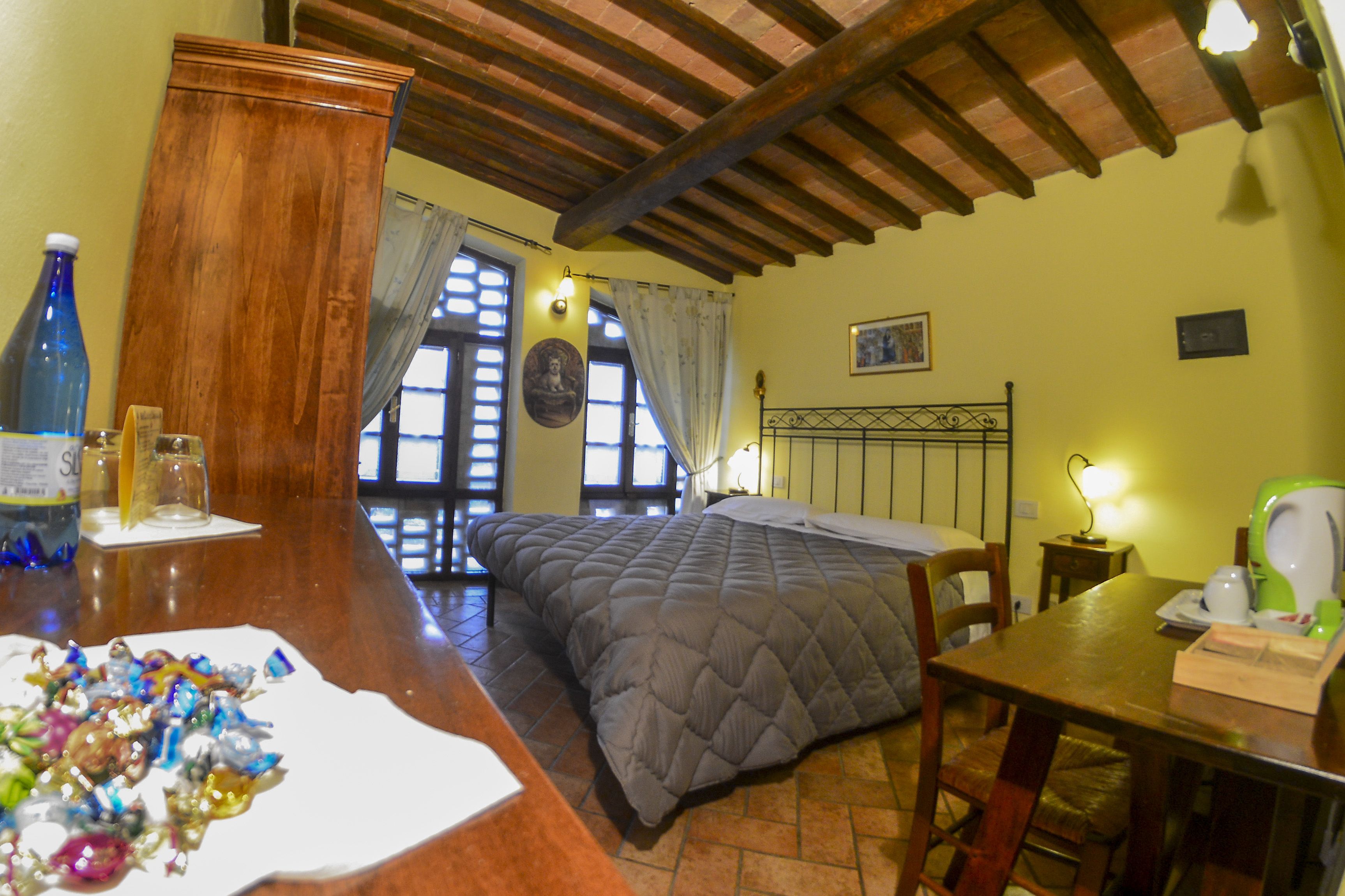 Una habitación acogedora con una cama, muebles de madera y una mesita de noche con una lámpara.