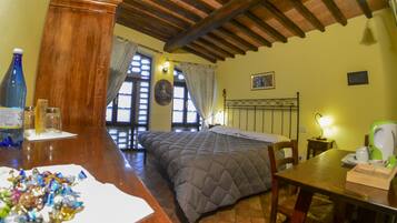 Una habitación acogedora con una cama, muebles de madera y una mesita de noche con una lámpara.