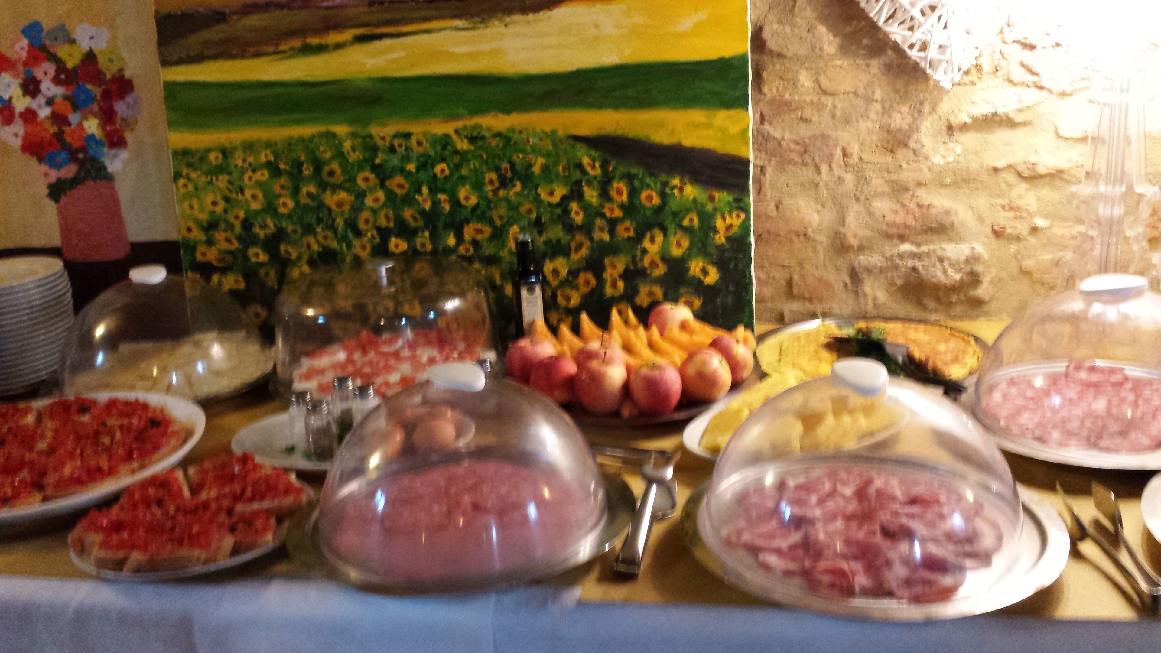 Ein Büfett mit verschiedenen Speisen, darunter Fleisch, Obst und Gemüse, bedeckt mit Glaskuppeln.