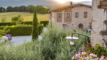 Escape to a serene garden oasis with a charming stone building and lush greenery.