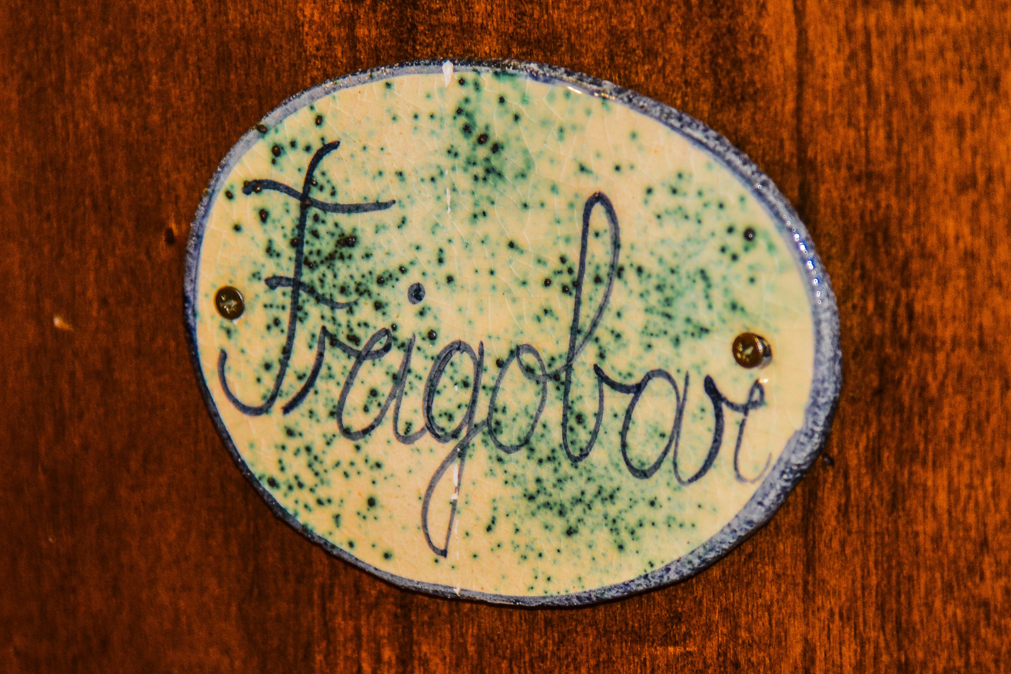 A wooden surface with a circular, oval-shaped label that has the word "Fragobar" written on it.