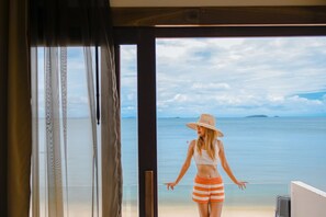A person standing by a large window overlooking a beach. - Samed Seaside Resort (Rayong)