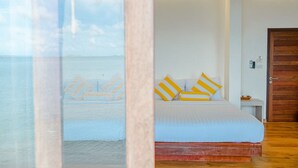 Un dormitorio con cama, una puerta de madera y vista a la playa.