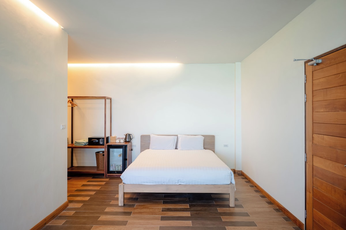 A bedroom with a bed, bedside table, and a wardrobe.