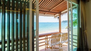 Una terraza de madera con un banco con vistas a la playa.