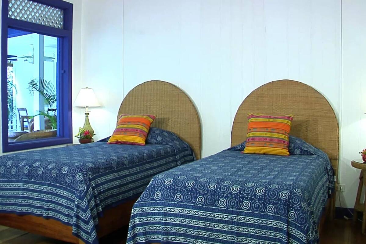 Two single beds with headboards, a window with a view, and bedside lamps.
