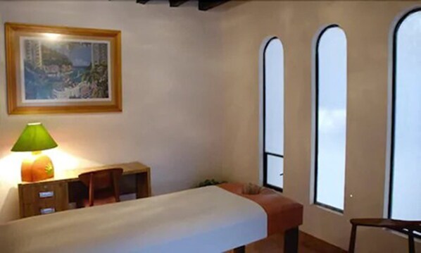 A room with a bed, a desk, a lamp, and a painting on the wall. - Bungalows Lolita (Ixtapan de la Sal)