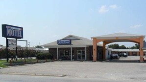 A motel with a large sign, a laundromat, and a parking lot. - A OK Motel (Muenster)