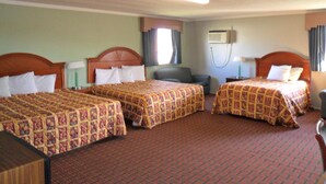 A hotel room with three beds, a desk, and a chair. There is an air conditioning unit on the wall. - A OK Motel (Muenster)