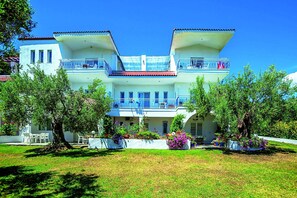 Stunning two-story building with a central balcony and beautifully manicured lawn.
