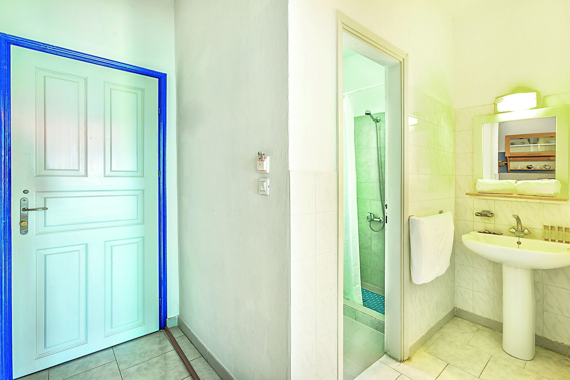 Une salle de bain avec une douche, un lavabo et un miroir.