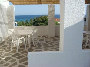 Relax in a serene outdoor space with a view of the sea and lush greenery.