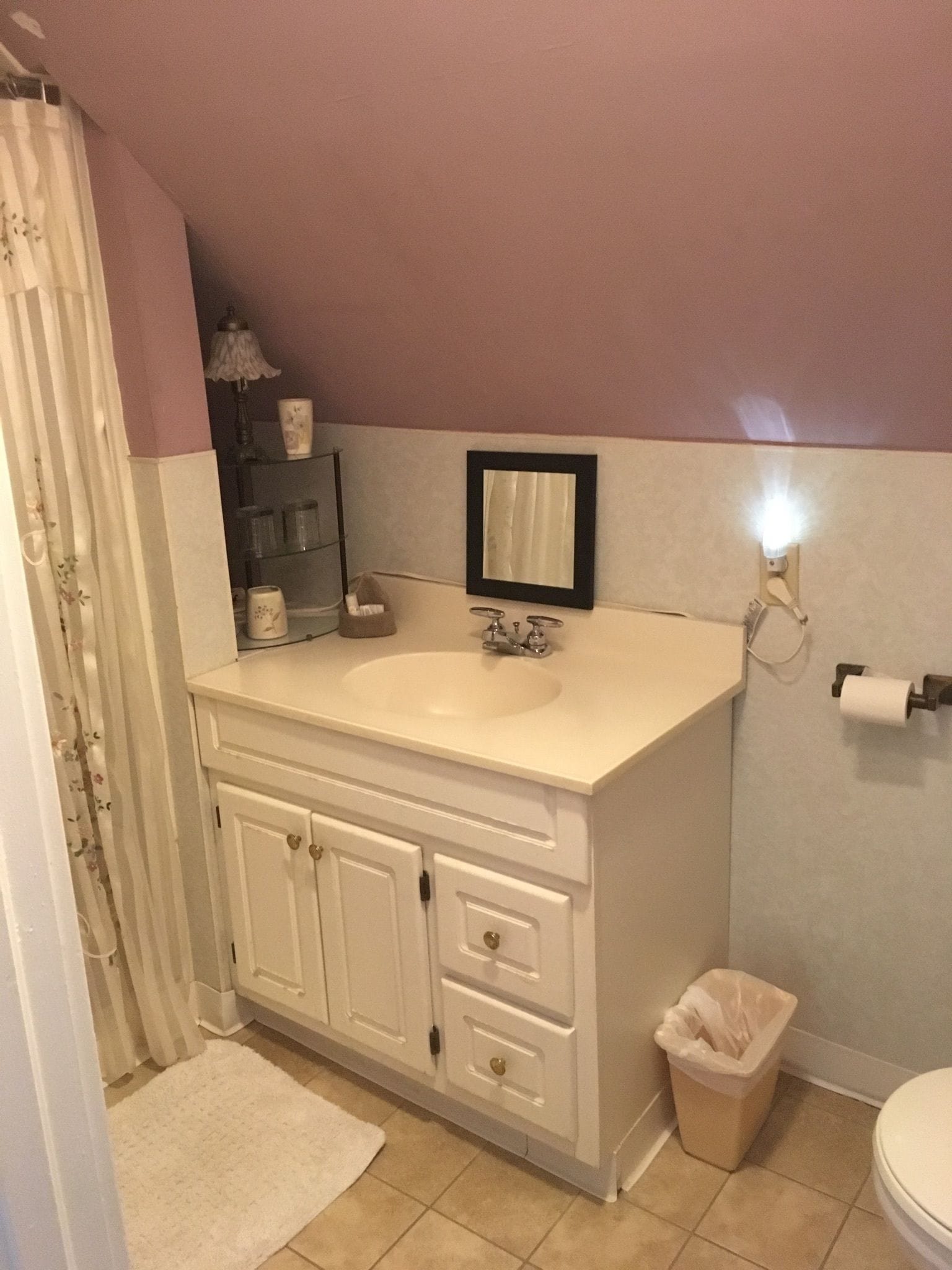 A bathroom with a white vanity, a mirror, a sink, and a toilet.