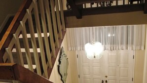 A wooden staircase with a handrail leading to a white door with a glass panel. - Bed and Breakfast in Hollywood Hills (Los Angeles)