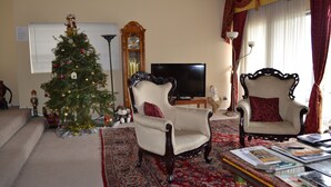 A living room with a Christmas tree, two armchairs, a television, and a bookshelf. - Bed and Breakfast in Hollywood Hills (Los Angeles)