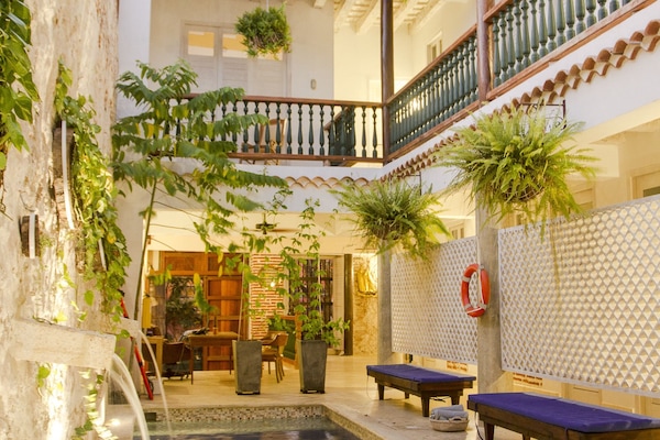 Una piscina al aire libre, sillones reclinables de piscina