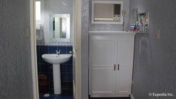 A bathroom with a white pedestal sink, a mirror above it, and a cabinet with a mirror above.
