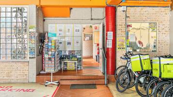 A storefront with a brick wall, a glass display case, and a bicycle delivery service.