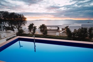 A pool with a view of the sea and a sunset.