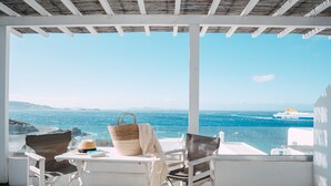 A terrace with white furniture, a woven basket, and a book. -  With-inn Mykonos Suites (Mykonos)