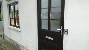 Un edificio blanco con una puerta negra y una ventana.