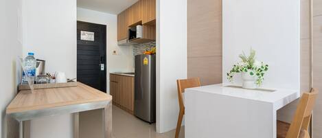Een moderne keuken met een houten aanrecht, roestvrijstalen apparatuur en een eethoek met een witte tafel en stoelen.