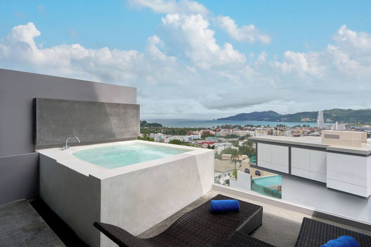 A modern bathroom with a large bathtub and a view of a cityscape.