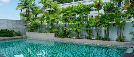 Una piscina al aire libre, sillones reclinables de piscina