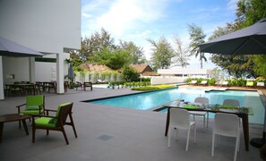 Una piscina al aire libre, sombrillas