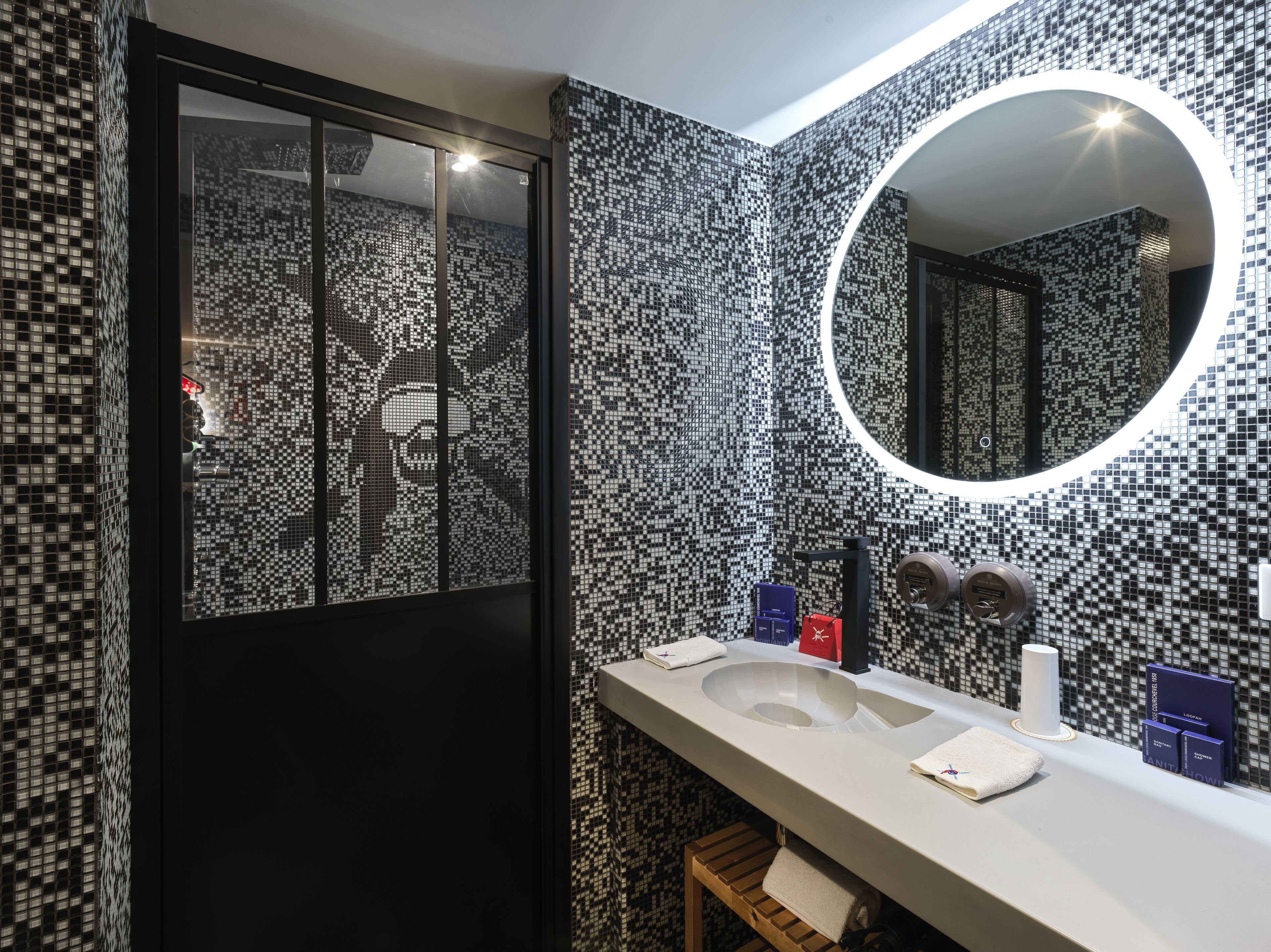A modern bathroom with a large mirror, a sink, and a toilet.